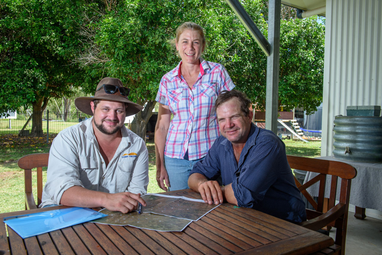 Graziers Bree and John Skinner, of White Kangaroo, pictured with NQ Dry Tropics Grazing Field Officer Brad Martin, checking an updated property map following infrastructure upgrades. 
