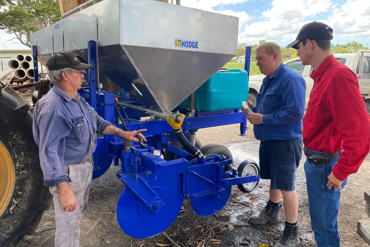 Pat Young (L) discusses modifications to his insecticide applicator with Project Bluewater support staff, Adam Keilbach (C) and Daniel New (R). Credit: Farmacist.