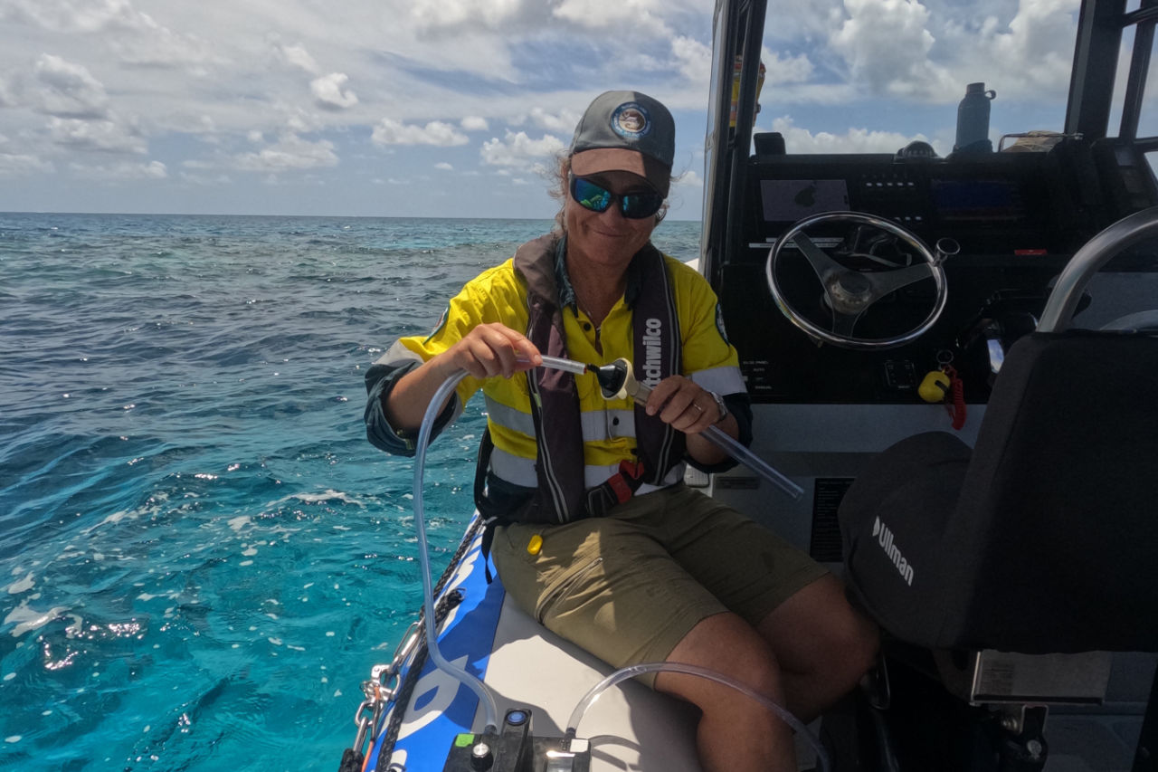 A Marine Parks ranger collecting samples of seawater for processing in the lab.