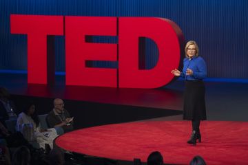 Theresa Fyffe delivering her TED talk on the red stage.