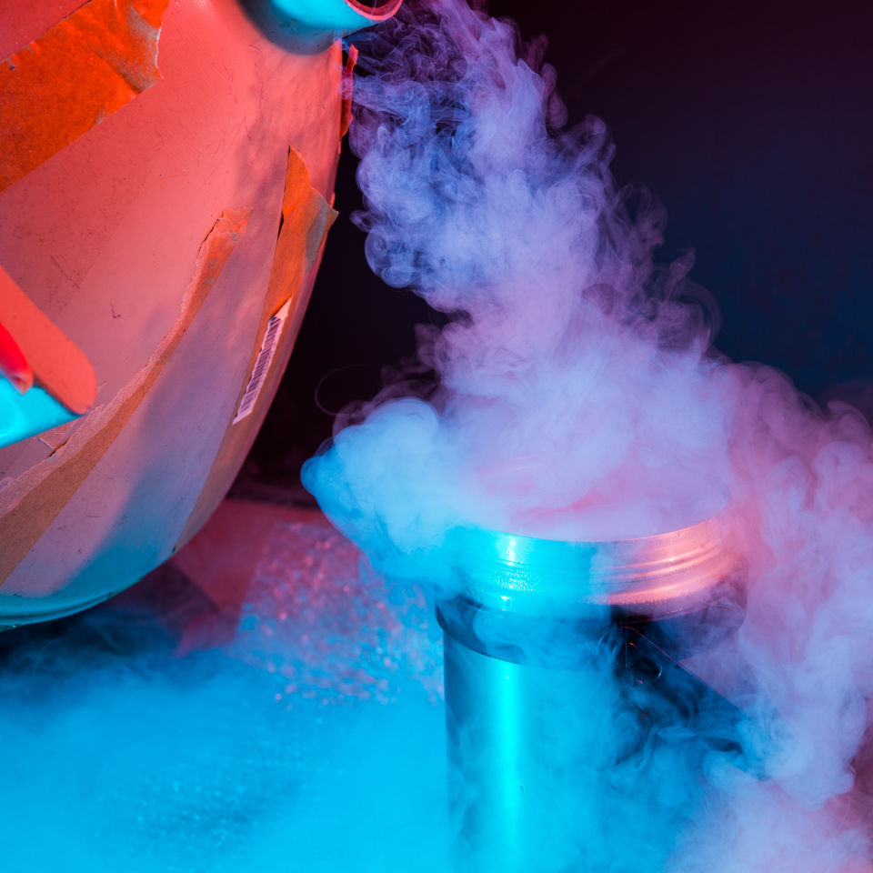 Researcher pouring freezing agent in cryopreservation process.