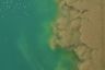 An aerial view of water pollution from flooding mixing with clean water.